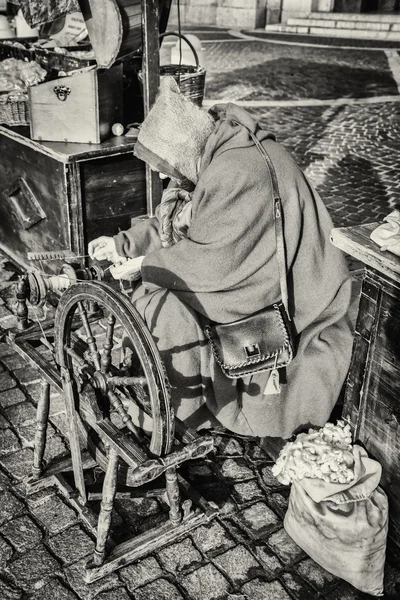 Пожилая женщина использует коконы шелкопрядов для вращения . — стоковое фото