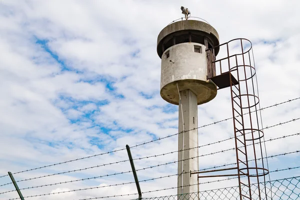 Torre de sentinela abandonada isolada por uma rede com arame farpado . — Fotografia de Stock