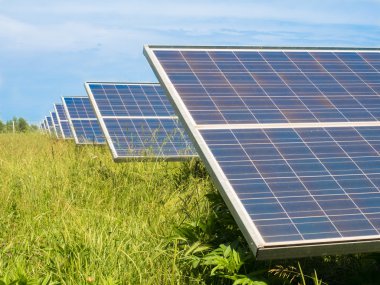 Yeşil bir çayırda fotovoltaik paneller.