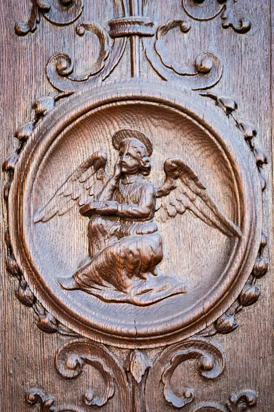 Ángel grabado en el portal de madera de una antigua iglesia . — Foto de Stock