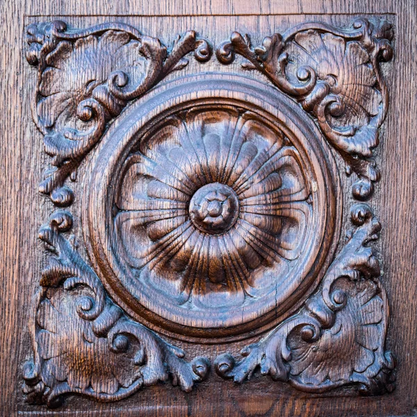 Flower engraved on the wooden portal of an ancient church. — Stock Photo, Image