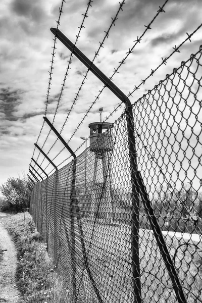 Opuštěná strážní budka věž izolovaná síť s ostnatým drátem. — Stock fotografie