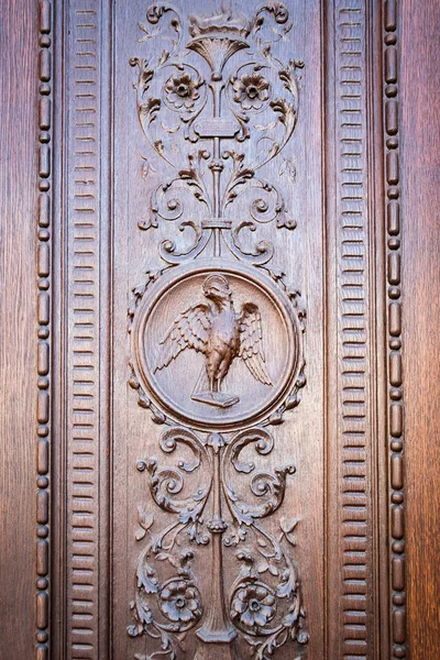 Águila grabada en el portal de madera de una antigua iglesia . — Foto de Stock