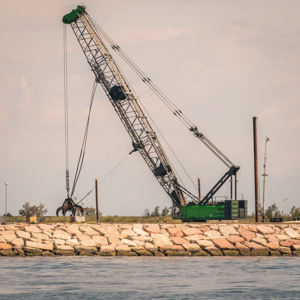 Grue de préhension en action pour la construction d'une digue . — Photo