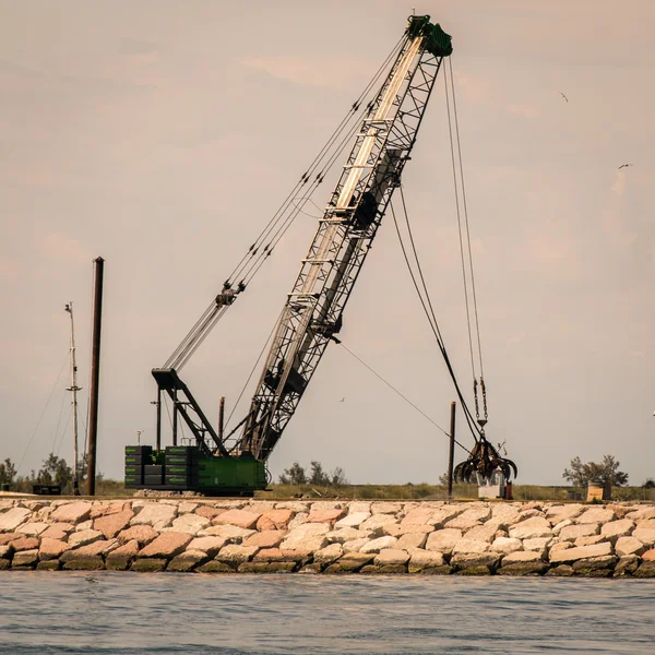 Grue de préhension en action pour la construction d'une digue . — Photo