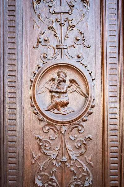 Ángel grabado en el portal de madera de una antigua iglesia . — Foto de Stock