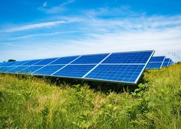 Painéis fotovoltaicos em um prado verde . — Fotografia de Stock