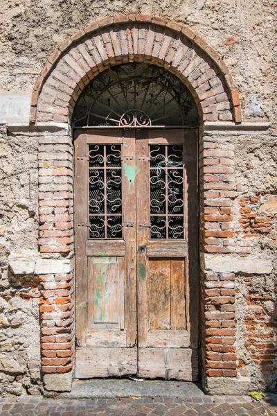 Old wooden door with brick archway. — Stock Photo, Image