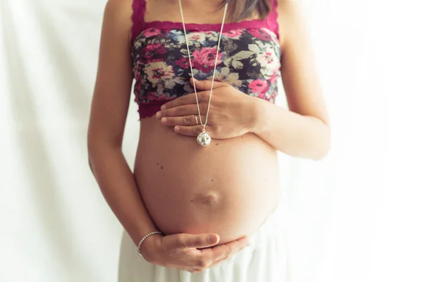 Zwangere vrouw met de bloem boven- en ketting. — Stockfoto