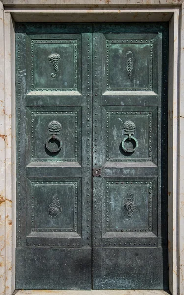 Porta de ferro com decorações esculpidas e batedores de porta circular . — Fotografia de Stock