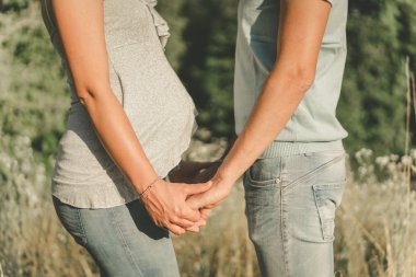 Çift birbirlerine karşı karşıya elele bir çocuk bekliyor.