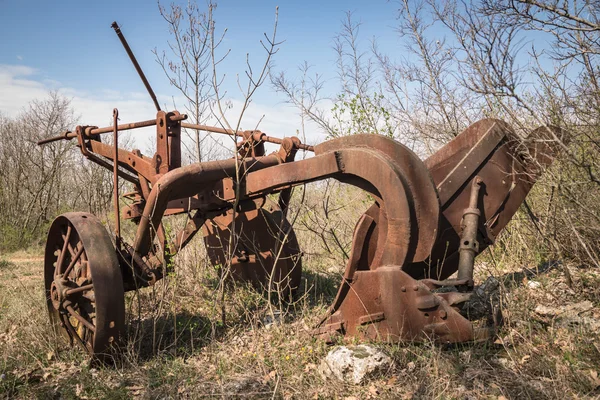 Velho arado de ferro enferrujado abandonado . — Fotografia de Stock