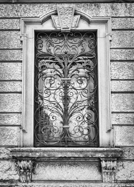 Окно старинной итальянской виллы с художественным железным грилем . — стоковое фото