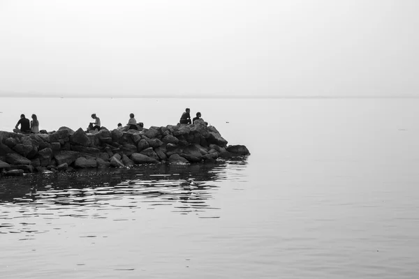 Gente relajándose en las rocas en el lago — Foto de Stock