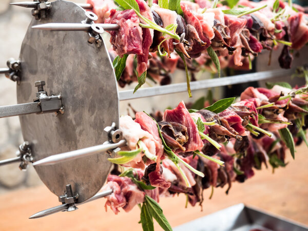 birds on the spit with meat, bacon and sage ready to be cooked