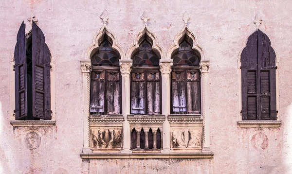 Viejas ventanas en una fachada del palacio medieval en Verona — Foto de Stock