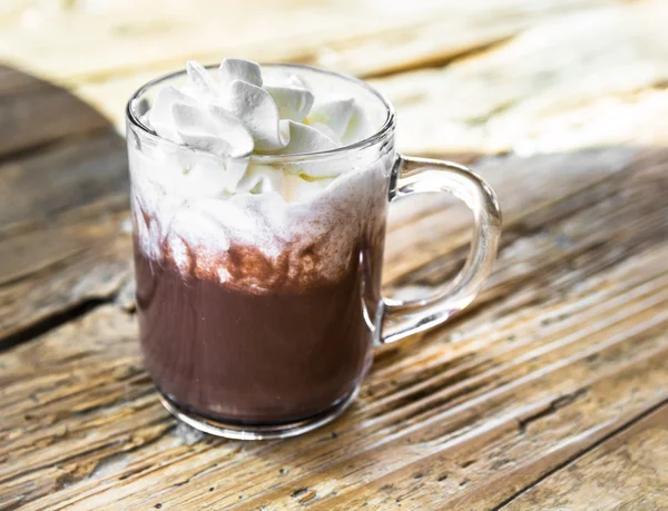 Bebida de chocolate con crema batida en taza transparente en madera — Foto de Stock