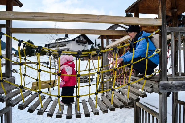 Mom and daughter in a snowy playground. — Stock Photo, Image