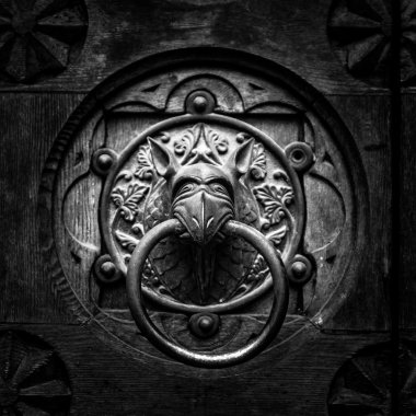 Antique door knocker shaped monster's head. clipart