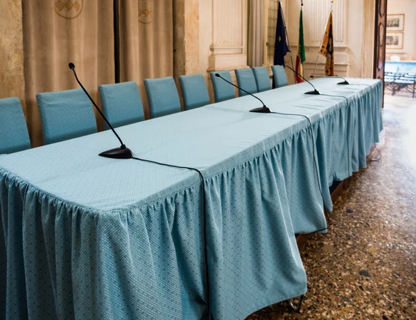 Conference table with black microphones and blue chairs. — Stock Photo, Image