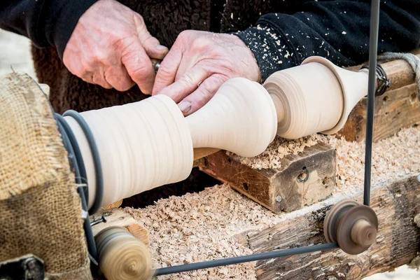 An artisan carves a piece of wood using a manual lathe. — Stock Photo, Image
