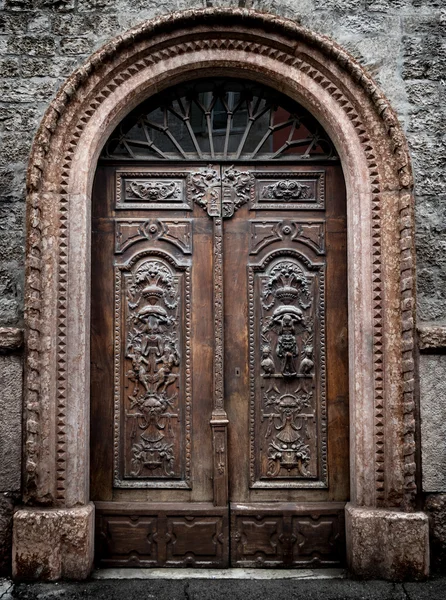 Old wooden gate engraved with demonic figures. — Stock Photo, Image