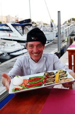 Ciutadella harbor, Menorca, Spain - July 09th of 2016: Local and international restaurants offer their creations to tourists in the historical harbor of this beautiful mediterranean village clipart