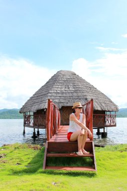 Ona zaman zevk ve yandup lodge's özel kabinler, yandup Adası, san blas, panama denize yakın oturan genç güzel kadın