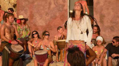 Benirras beach, Ibiza, İspanya - 23 Temmuz 2006: bir sürü insan oynarken davul ve diğer enstrümanlar gün batımını izlemek. Bu geleneksel kutlama tüm Pazar Temmuz ve Ağustos yer alır.