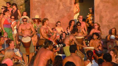 Benirras beach, Ibiza, İspanya - 23 Temmuz 2006: bir sürü insan oynarken davul ve diğer enstrümanlar gün batımını izlemek. Bu geleneksel kutlama tüm Pazar Temmuz ve Ağustos yer alır.