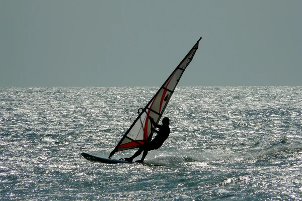Yalnız bir adet Rüzgar Sörfü deniz harika bir gün batımı sırasında Jericoacoara'nın ana plaj, Brezilya sürme.
