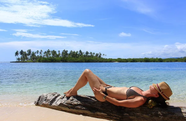 Young beautiful woman enjoying her time and resting close to the sea in the southern beach of 