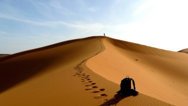 Top, büyük kumul içinde kırmızı dune deniz, Erg African, Fas için tırmanma uzun yürüyüşe çıkan kimse.