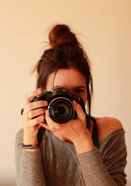 Young female photographer with camera on soft background — Stock Photo, Image