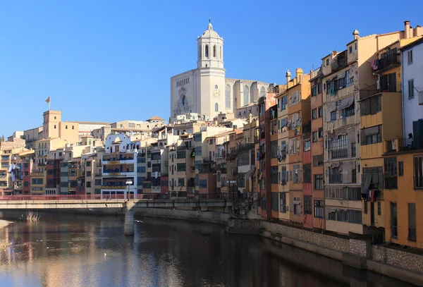 Casas coloridas colocadas perto do rio Onyar com a incrível torre principal da catedral ao contrário, Girona, Espanha . — Fotografia de Stock