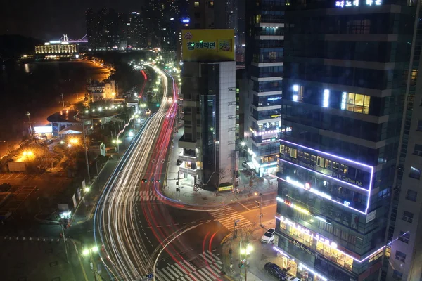 韩国釜山-2015 年 3 月 26 日: 夜景的几个建筑物和海滩主路. — 图库照片