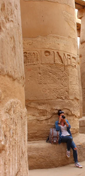 Jeune belle femme prenant des photos entre les colonnes de la salle hypostyle du temple de Karnak à Louxor, Egypte . — Photo