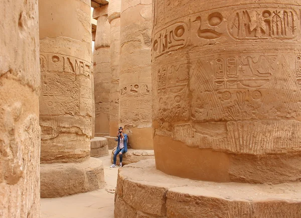 Junge schöne Frau beim Fotografieren zwischen den Säulen der Hypostilhalle des Karnak-Tempels in Luxor, Ägypten. — Stockfoto