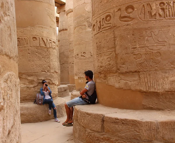 Jeune couple prenant des photos entre les colonnes de la salle hypostyle du temple de Karnak à Louxor, Egypte . — Photo