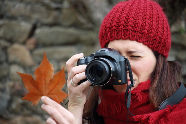 Young beautiful woman taking pictures to beech leaves in one of the most amazing beech forest in Europe, "La Fageda d'en Jorda", a nature paradise placed close to Olot village, Catalonia, Spain.