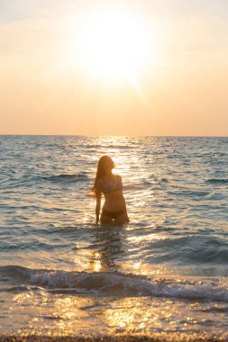Güzel genç kız sahilde dinleniyor.