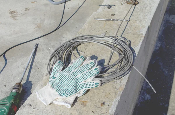Строительные перчатки на катушке проволоки — стоковое фото