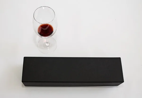 En lyxig svart närvarande väska och ett glas vin separerade på vit bakgrund Stockbild