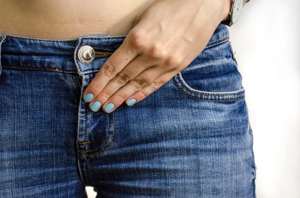 Jeans and a female hand with blue nail polish