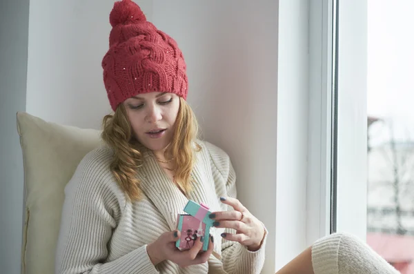 Kırmızı şapkalı onu pencere mevcut tutan genç kadın