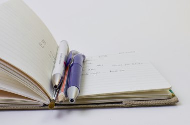 defter ile parlak kapak ve beyaz arka plan üzerinde izole kalem