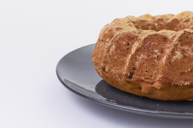 Beyaz arka plan üzerinde koyu seramik plaka üzerinde üzümlü kek ayrılmış