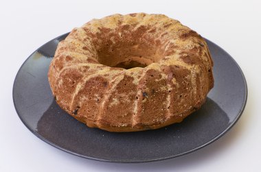 Beyaz arka plan üzerinde koyu seramik plaka üzerinde üzümlü kek ayrılmış