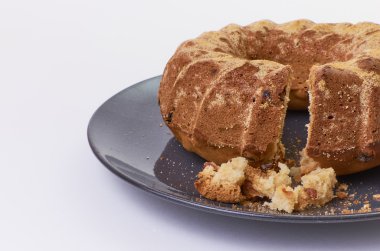 Beyaz arka plan üzerinde koyu seramik plaka üzerinde üzümlü kek ayrılmış