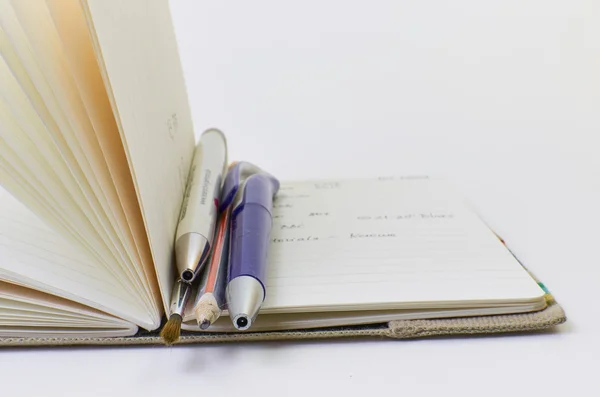 defter ile parlak kapak ve beyaz arka plan üzerinde izole kalem